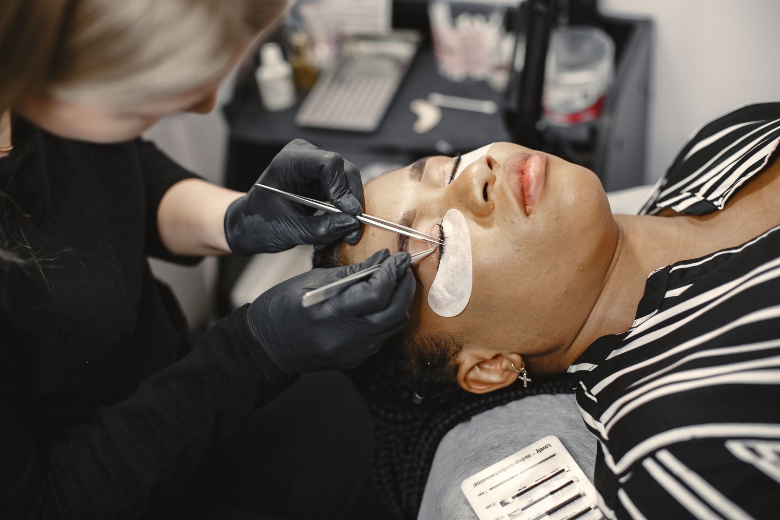 Lash technician applying eyelash extensions